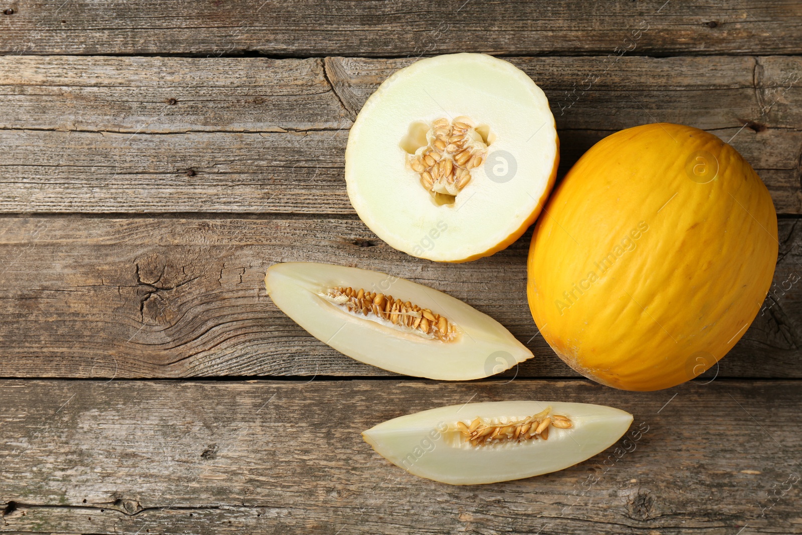 Photo of Fresh ripe melons on wooden table, flat lay. Space for text