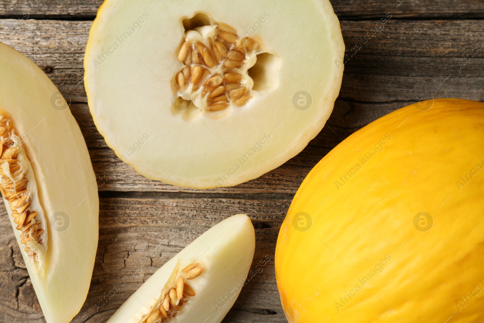 Photo of Fresh ripe melons on wooden table, flat lay