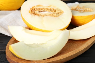 Fresh ripe melons on black wooden table, closeup