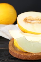 Fresh ripe melons on black wooden table, closeup