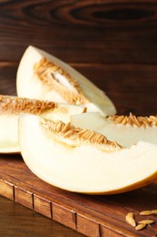 Photo of Cut fresh ripe melon on wooden table, closeup