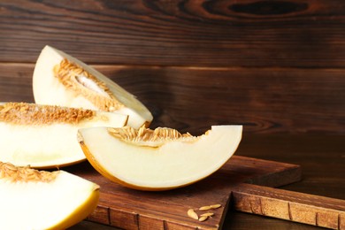 Cut fresh ripe melon on wooden table, space for text