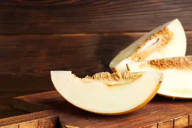 Cut fresh ripe melon on wooden table, space for text