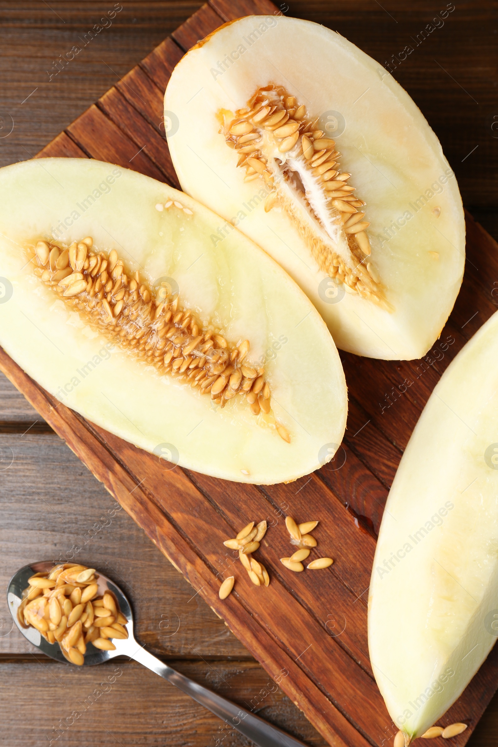 Photo of Cut fresh ripe melon on wooden table, top view