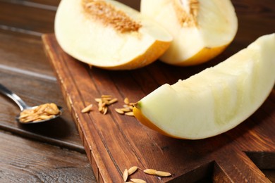 Photo of Cut fresh ripe melon on wooden table, closeup