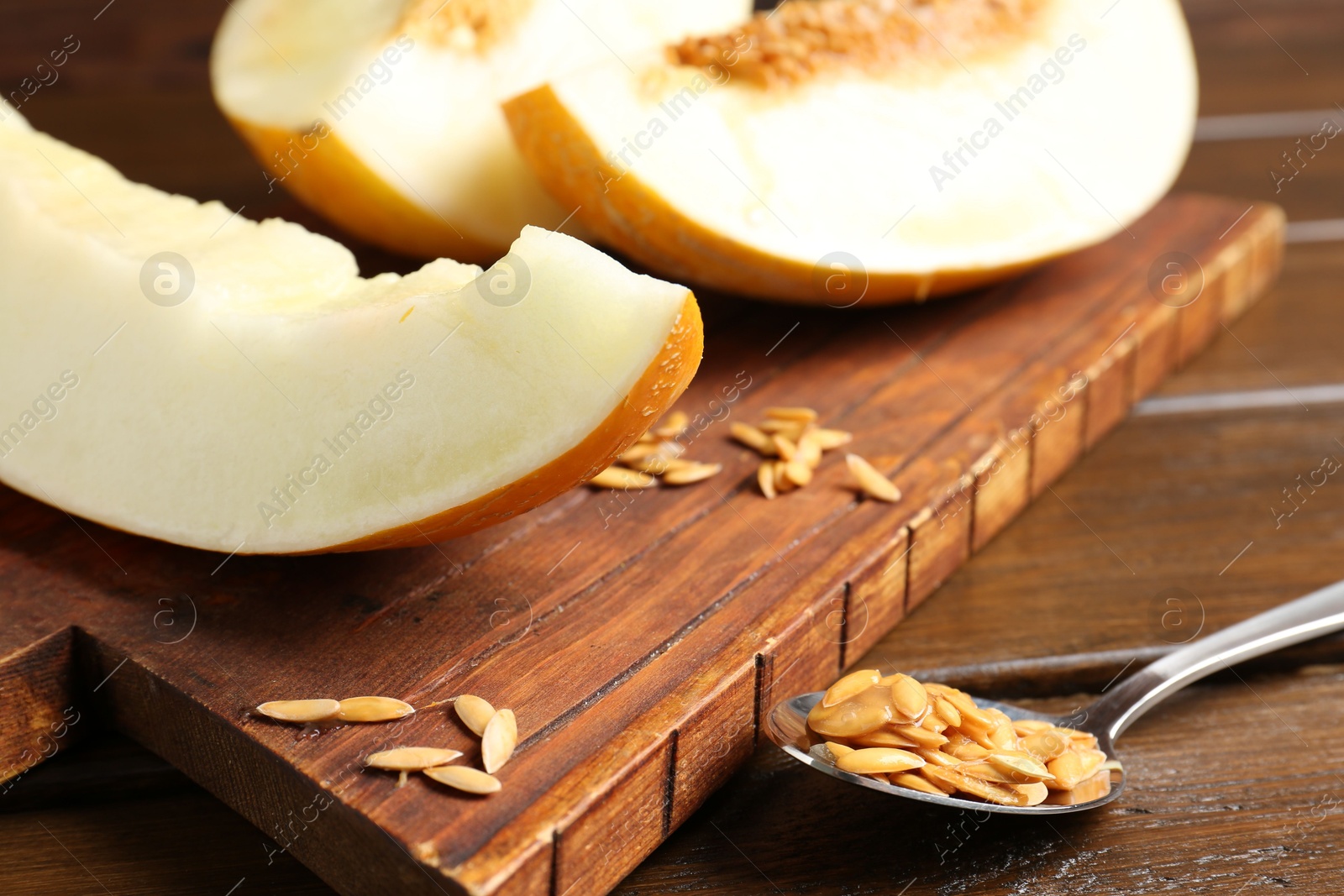 Photo of Cut fresh ripe melon on wooden table, closeup