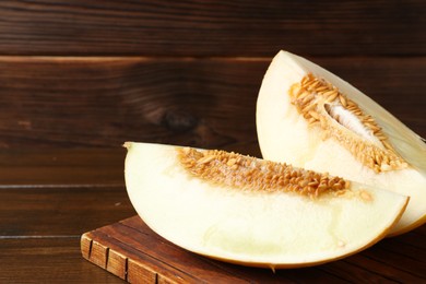 Cut fresh ripe melon on wooden table, space for text