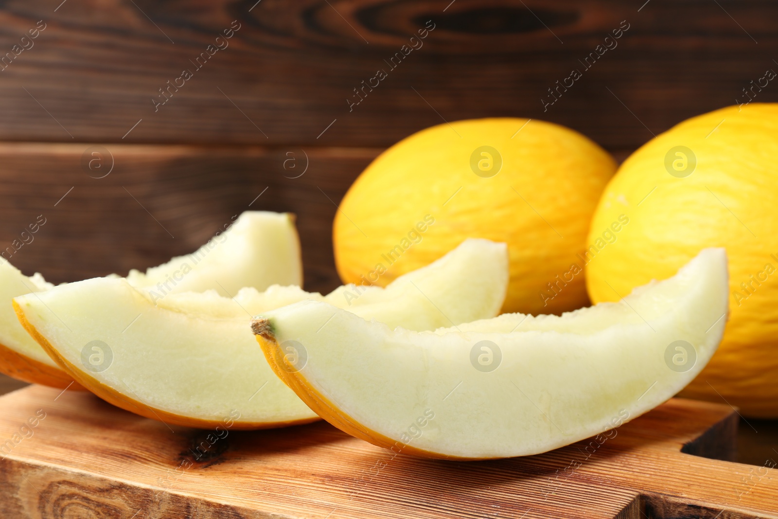 Photo of Fresh ripe melons on wooden table, closeup