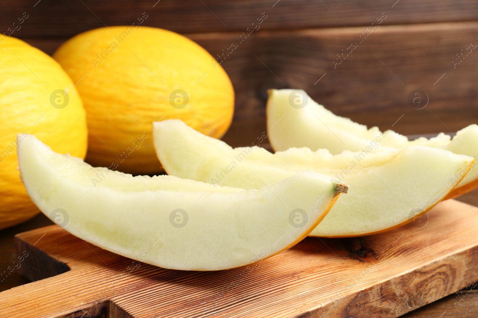 Photo of Fresh ripe melons on wooden table, closeup