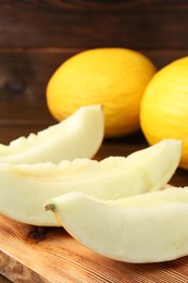 Photo of Slices of fresh ripe melon on wooden board, closeup