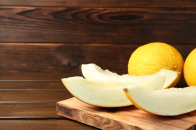 Photo of Fresh ripe melons on wooden table, space for text