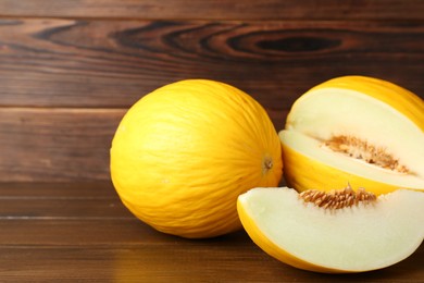 Fresh ripe melons on wooden table, space for text