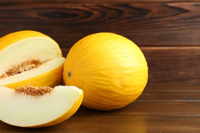 Fresh ripe melons on wooden table, space for text