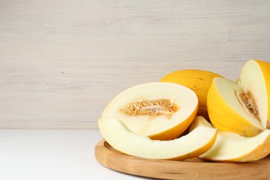 Photo of Fresh ripe melons on wooden table, space for text