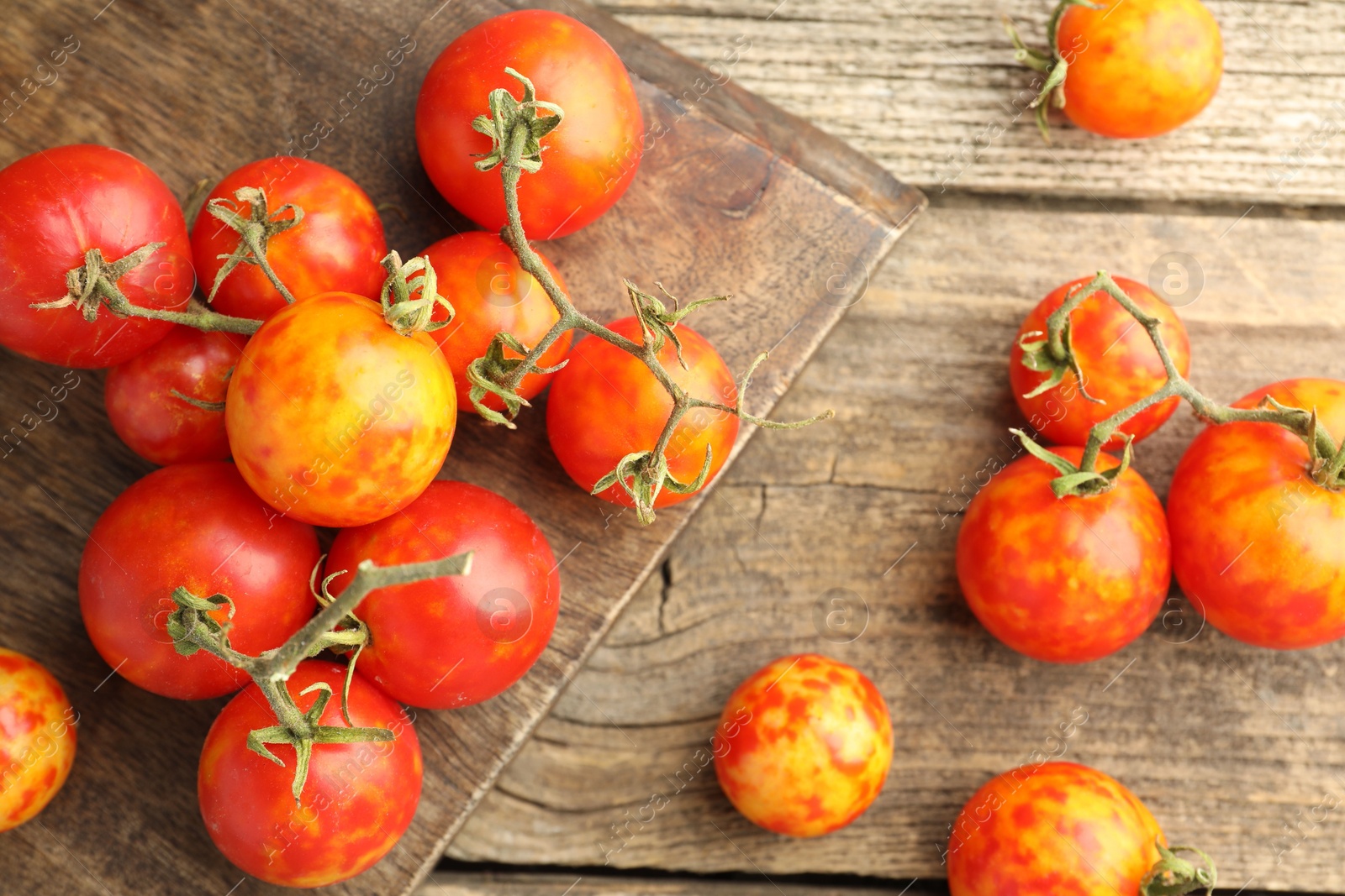 Photo of Fresh ripe tomatoes on wooden table, flat lay