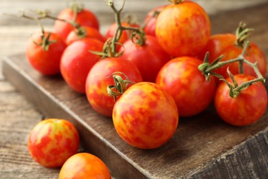 Fresh ripe tomatoes on wooden table, closeup