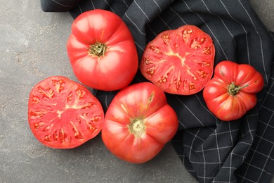 Photo of Whole and cut ripe red tomatoes on grey table, top view