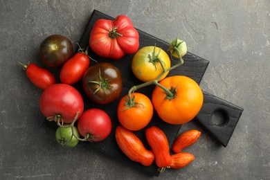 Different ripe tomatoes on grey table, top view