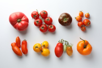 Photo of Different ripe tomatoes on white background, flat lay