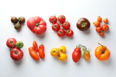 Photo of Different ripe tomatoes on white background, flat lay