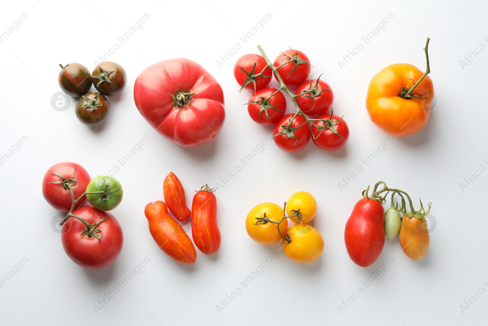 Photo of Different ripe tomatoes on white background, flat lay