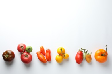 Different ripe tomatoes on white background, top view. Space for text