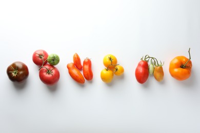 Photo of Different ripe tomatoes on white background, flat lay