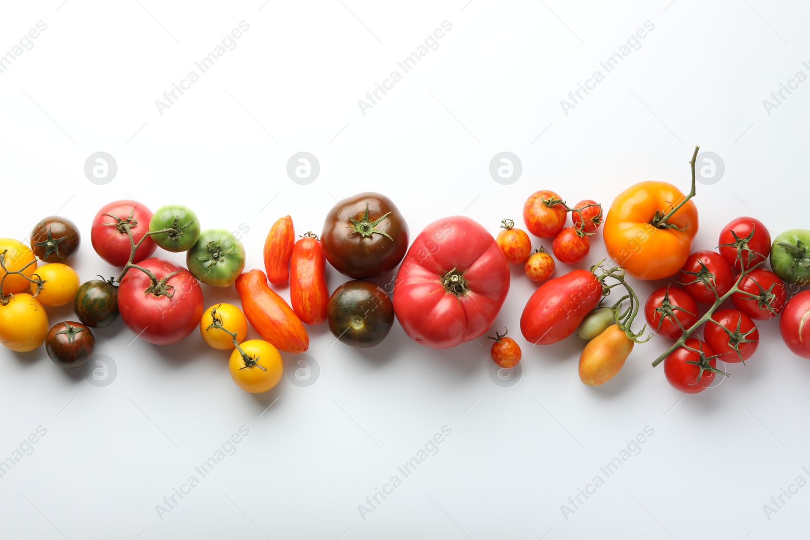 Photo of Different ripe tomatoes on white background, flat lay