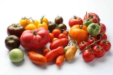 Many different ripe tomatoes on white background