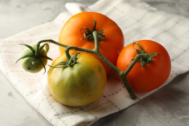 Photo of Branch of yellow tomatoes on grey textured table, closeup