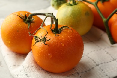 Photo of Branch of yellow tomatoes on grey textured table, closeup