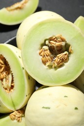 Photo of Fresh ripe honeydew melons on dark table, above view