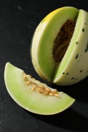 Photo of Fresh ripe honeydew melon on dark table, closeup