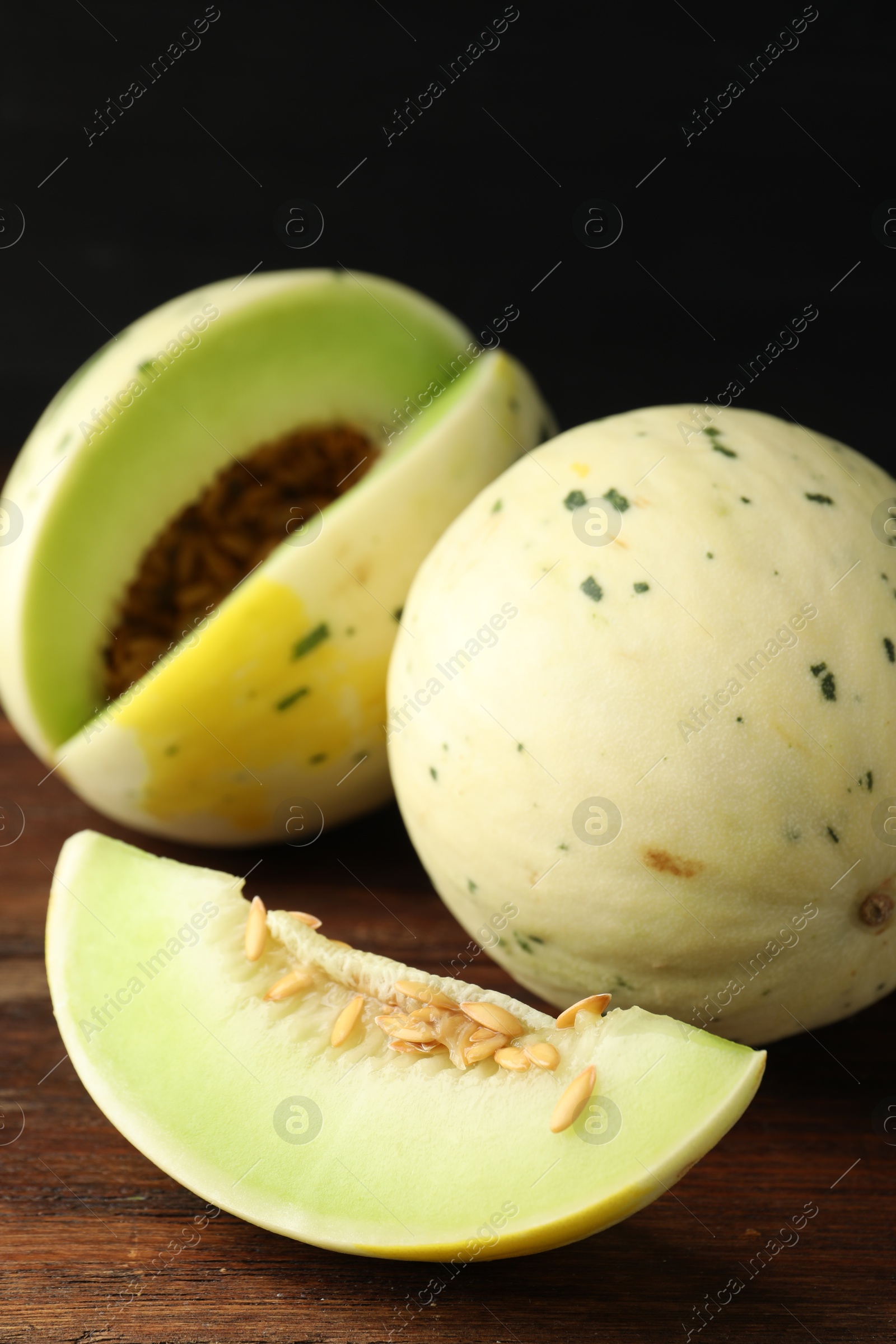 Photo of Fresh ripe honeydew melons on wooden table, closeup