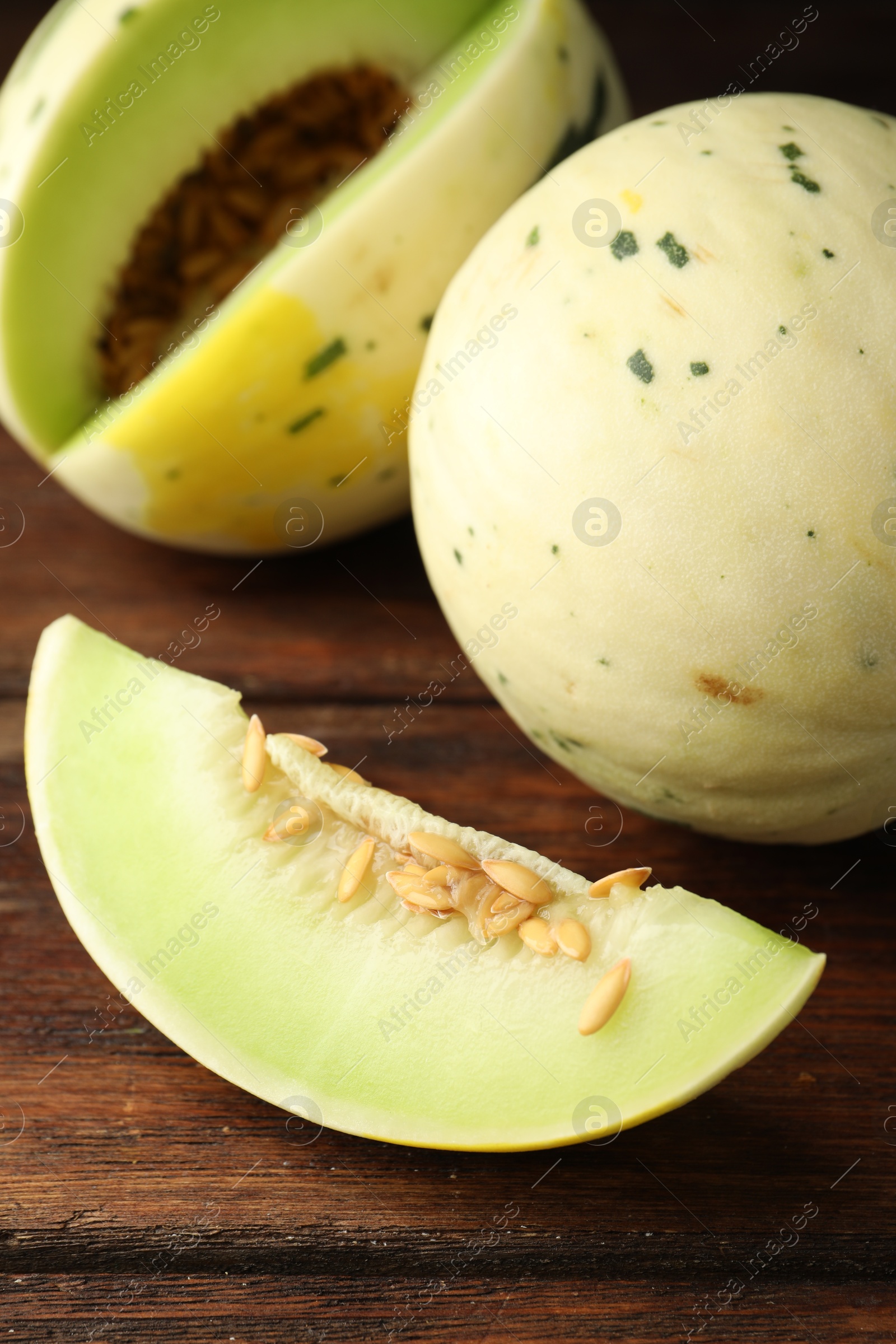 Photo of Fresh ripe honeydew melons on wooden table, closeup