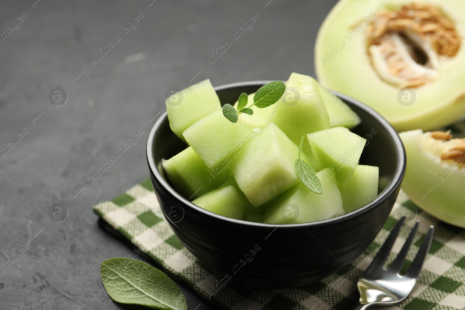 Photo of Slices of yummy melon on dark table, closeup. Space for text