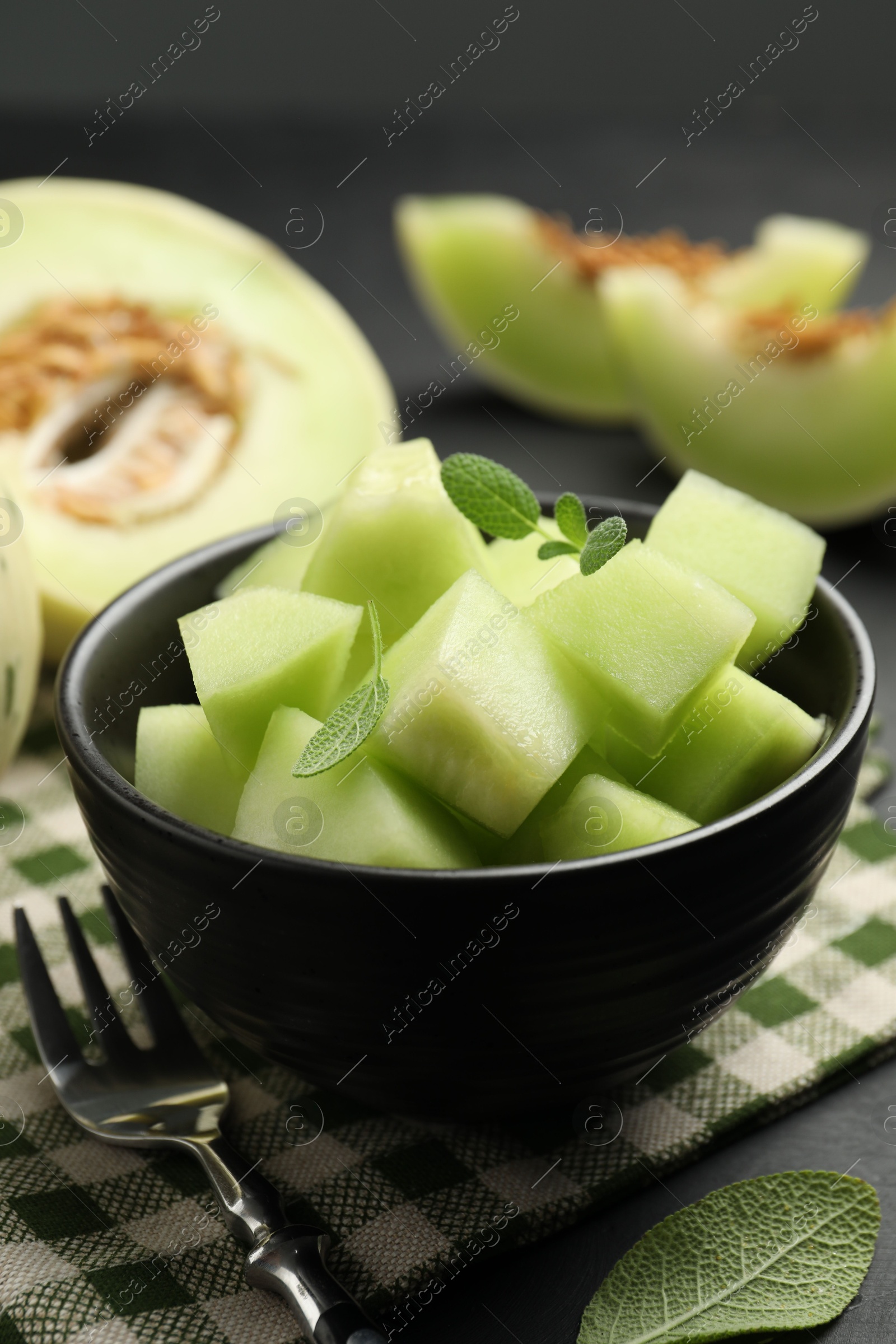 Photo of Slices of yummy melon on dark table, closeup