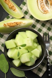 Photo of Slices of yummy melon on dark table, flat lay