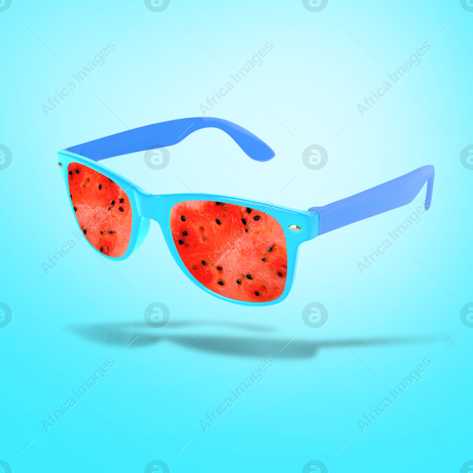 Image of Sunglasses with juicy watermelon in air on light blue background. Summer vibe