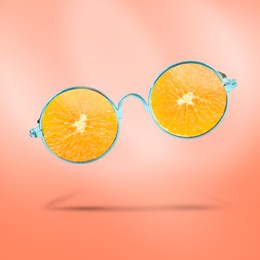 Sunglasses with juicy orange in air on coral background. Summer vibe