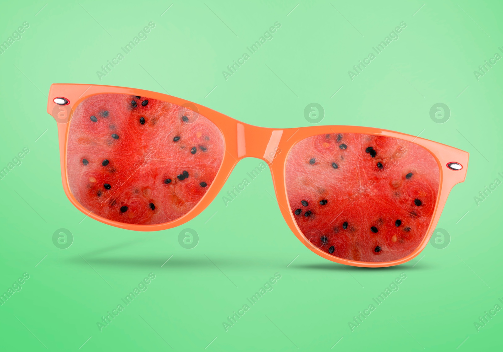 Image of Sunglasses with juicy watermelon in air on aquamarine background. Summer vibe