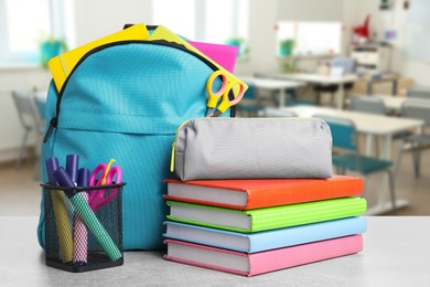 Image of Light blue backpack with stationery on school desk in classroom