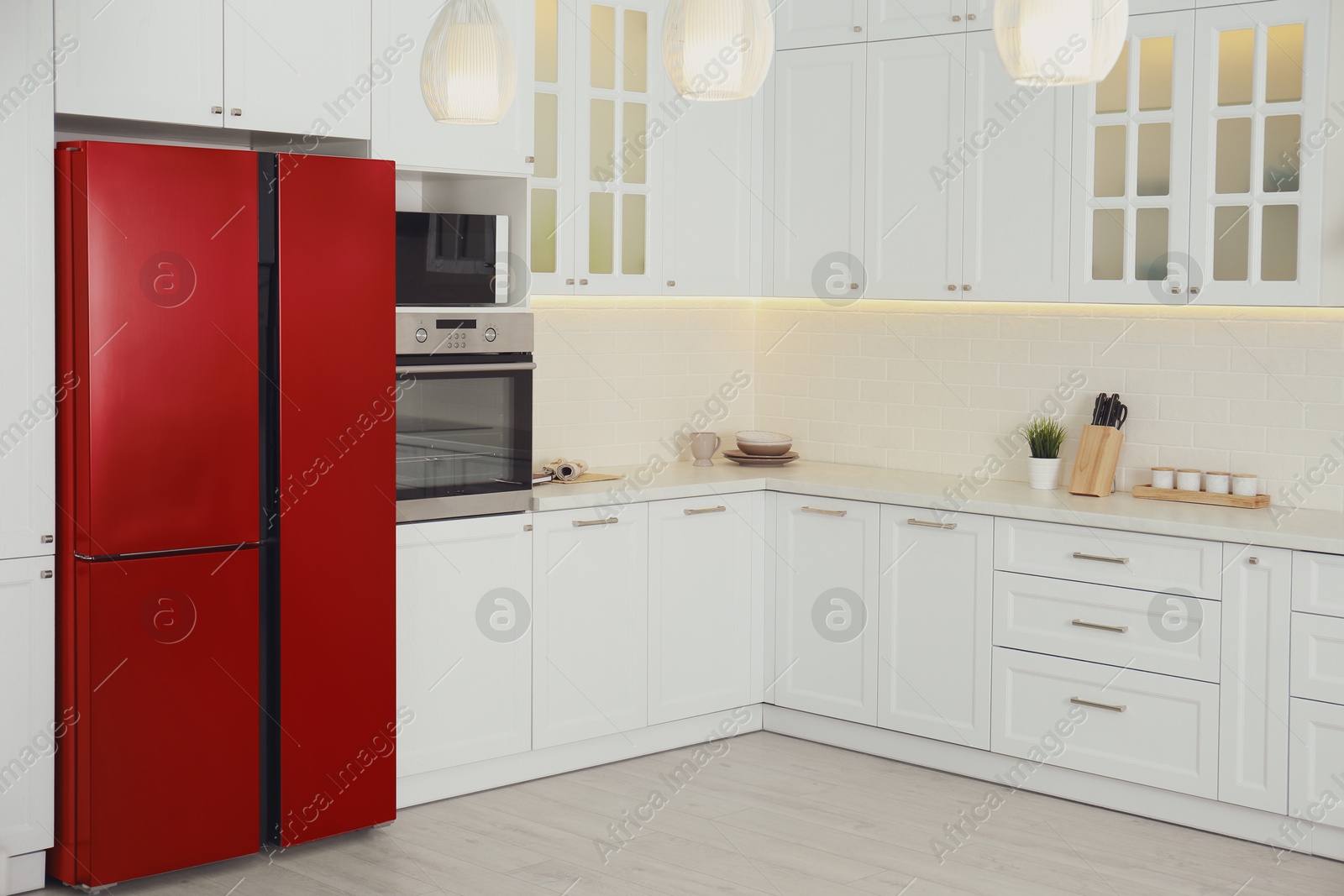 Image of Red refrigerator in kitchen. Bright color accent in interior