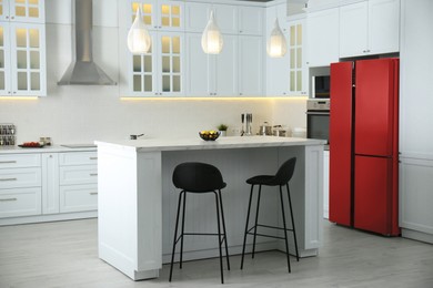 Image of Red refrigerator in kitchen. Bright color accent in interior