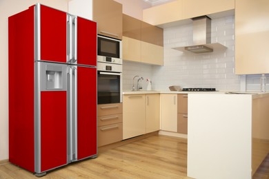 Image of Red refrigerator in kitchen. Bright color accent in interior