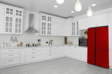 Image of Red refrigerator in kitchen. Bright color accent in interior