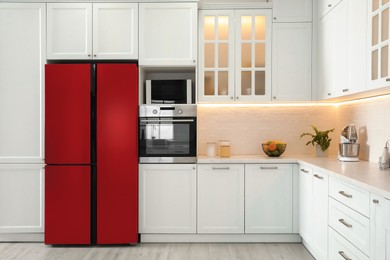 Image of Red refrigerator in kitchen. Bright color accent in interior