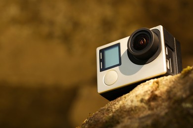 Modern action camera on stone, closeup. Space for text