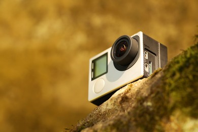 Photo of Modern action camera on stone, closeup. Space for text