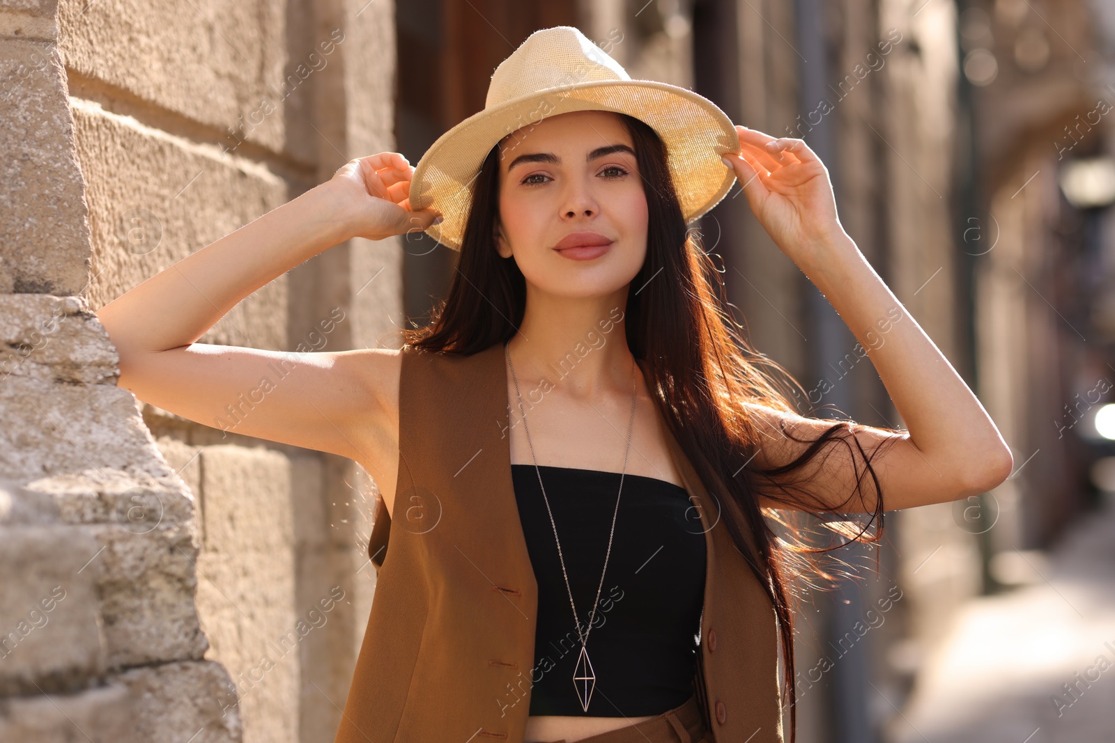 Photo of Beautiful young woman in stylish hat on city street